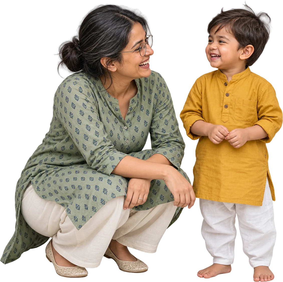 An educator crouched to the height of a boy of about three, the two of them looking at each other.